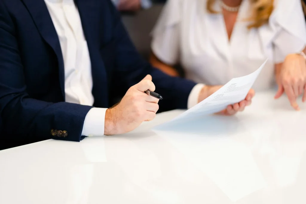 Duas pessoas analisando um documento em reunião