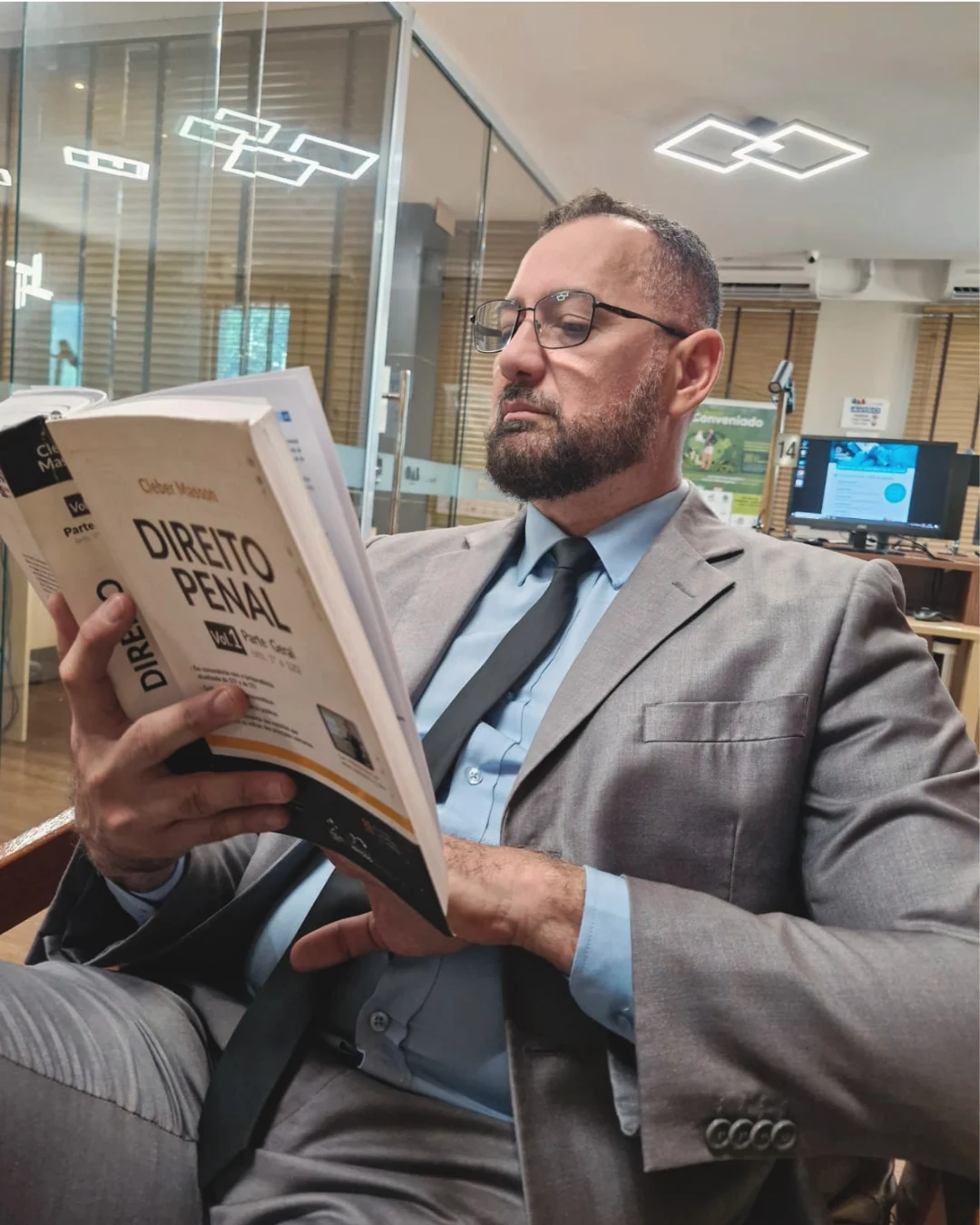Dr. Márcio Carvalho, advogado (OAB/AM 5274), lendo um livro no escritório